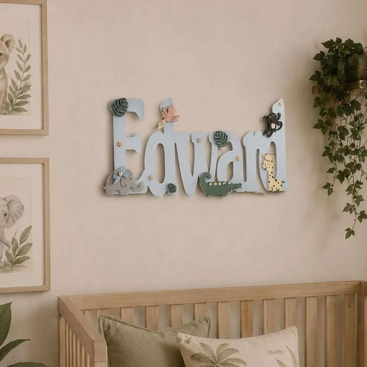 Over cot wooden Name sign painted in light blue with Safari Animals